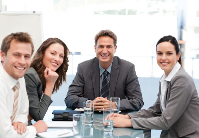 Portrait of a positive team sitting at a table during a meeting